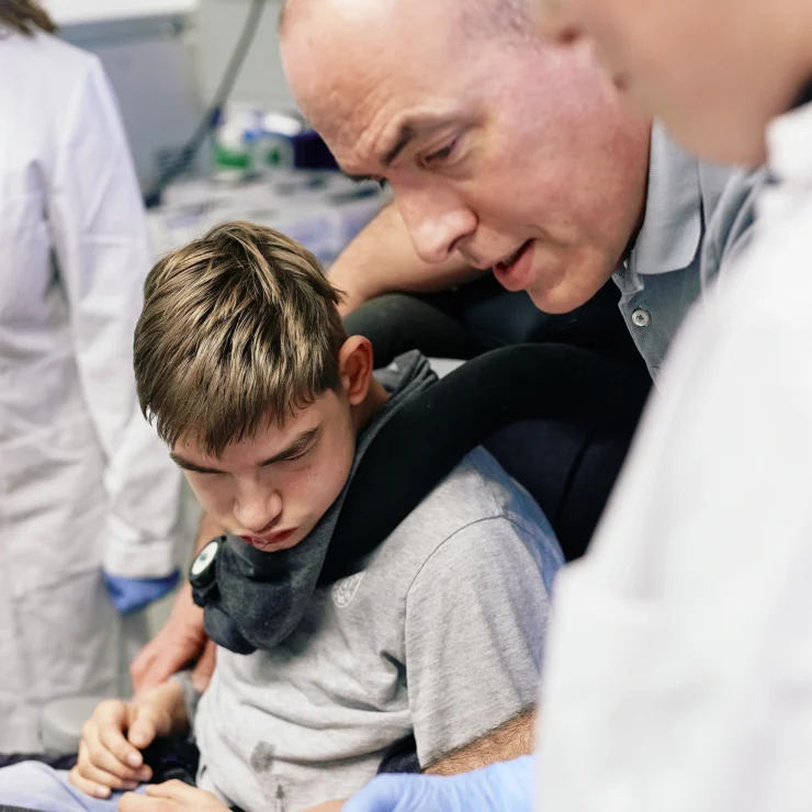Ein Vater und sein Sohn sehen sich im Labor eine Probe an.